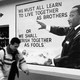 A man walking in front of an MLK mural