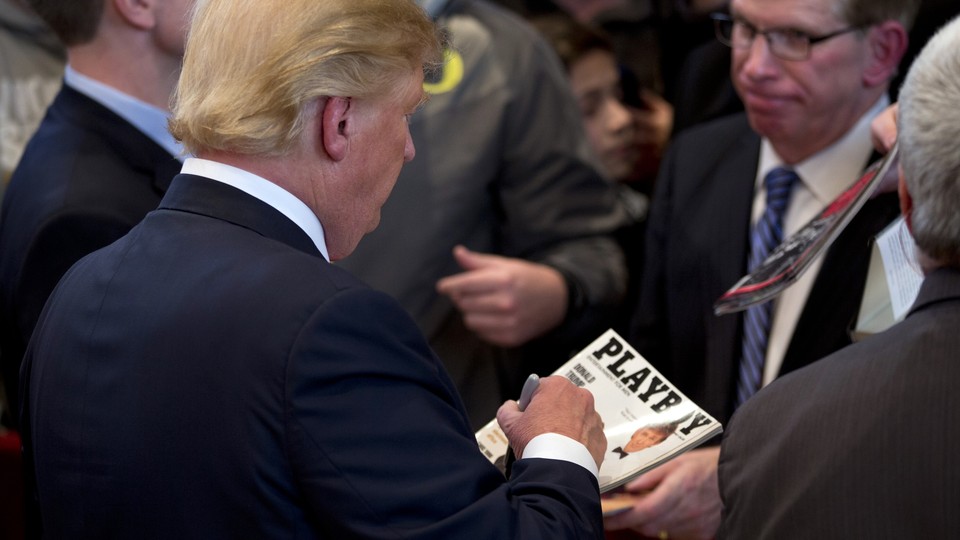 Donald Trump signs a copy of his cover of Playboy magazine.