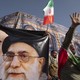 An Iranian protester shouts anti-U.S. and anti-Israeli slogans while standing next to the portraits of Iran's supreme leader, Ayatollah Ali Khamenei, and late leader, Ayatollah Ruhollah Khomeini.