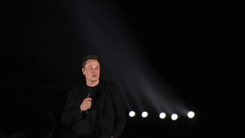 Elon Musk speaks into a microphone