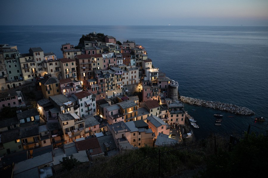A small Italian village of many buildings clustered on a steep coastal hillside