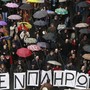 Protesters march under umbrellas during an anti-government rally