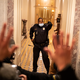 Photo of Capitol Police Officer Eugene Goodman standing in doorway of Capitol Building stairwell on January 6, 2021, with hand raised, opposite a crowd of rioters