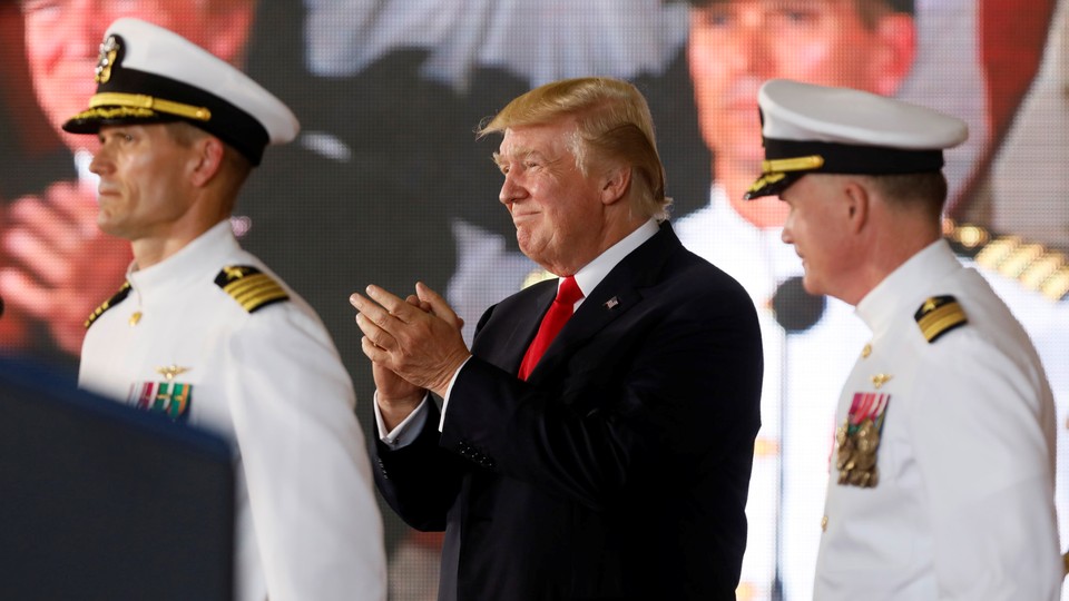 President Donald Trump stands with military personnel