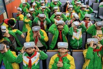 A group of kids in green and yellow school uniforms wearing VR headsets