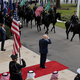 Photograph of Donald Trump saluting a procession of soldiers waving the U.S. and Saudi Arabian flags
