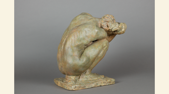 photo of sculpture of crouching woman seen from the back