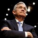 Jerome Powell looking up with arms crossed