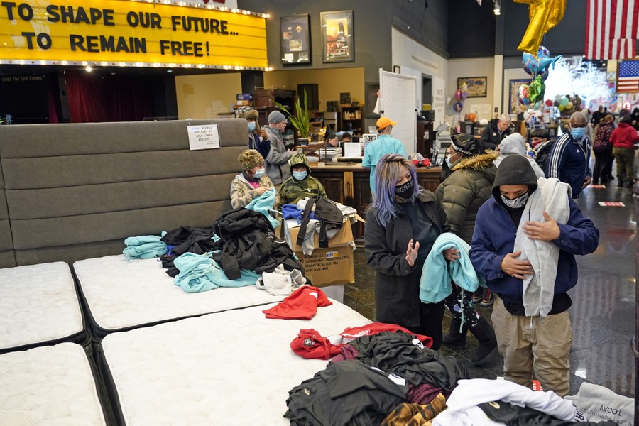 People select garments being given away inside a furniture store.