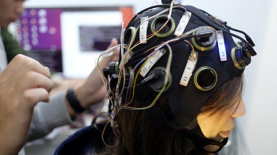A woman wearing a brain-scanning helmet