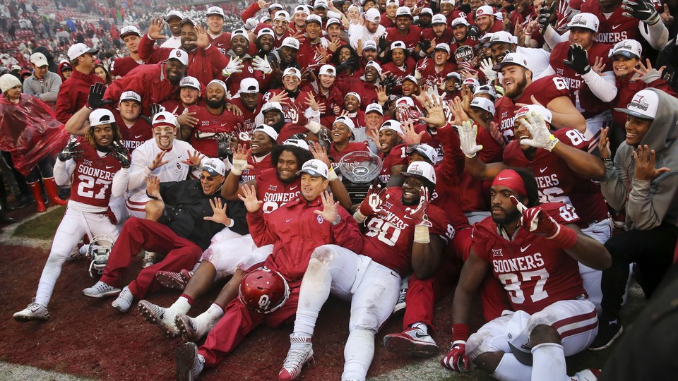 The Oklahoma Sooners pose for a photo with the Big 12 Championship trophy.