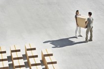 A man and a woman carrying a box together.