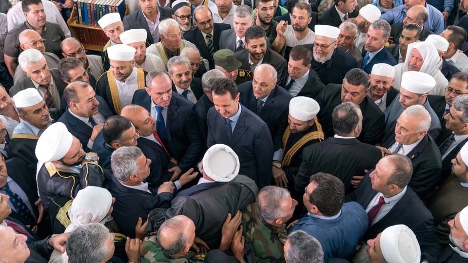 Assad stands in the middle of a throng of supporters, who greet him after Eid al-Fitr prayers at a mosque in Tartous.