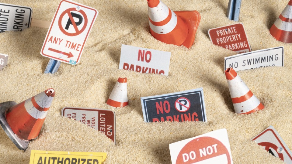 Traffic cones and "Private Property" and "No Trespassing" signs scattered in sand