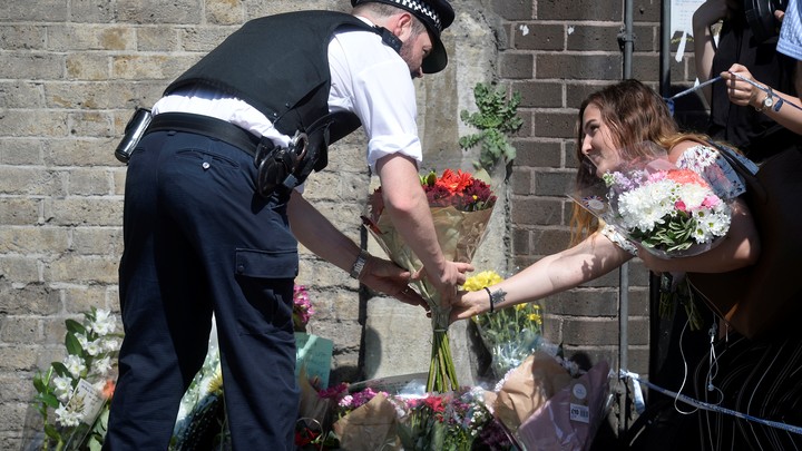 People leave flowers at a makeshift memorial where a man drove a van into Muslims outside a mosque in London.