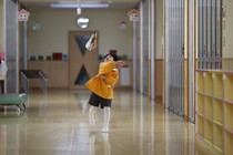 A boy plays in the hallway of a school in Japan