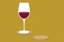 A wine glass half full with red wine on a yellow background