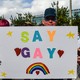 Person holding a sign with the words "SAY GAY" on it