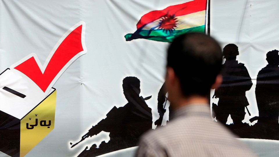 A man looks at a banner supporting the referendum for independence of Kurdistan