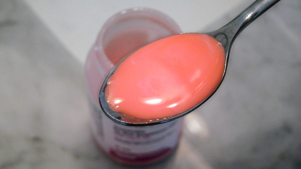 A spoonful of pink amoxicillin liquid