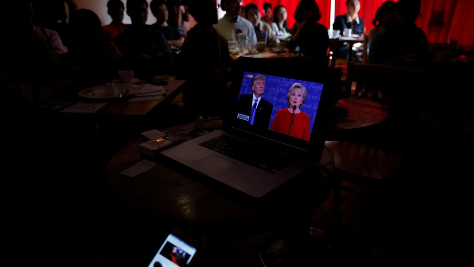 People watch direct broadcast of first U.S. presidential debate between Republican U.S. presidential nominee Donald Trump and Democratic U.S. presidential nominee Hillary Clinton at a cafe in Beijing, China, September 27, 2016. 
