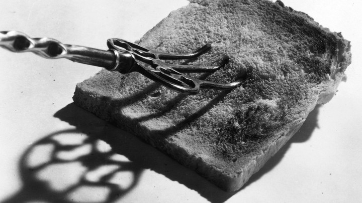 A photo of a piece of toast being stabbed with a fork.