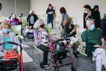 Seniors in masks wait for a coronavirus vaccine.