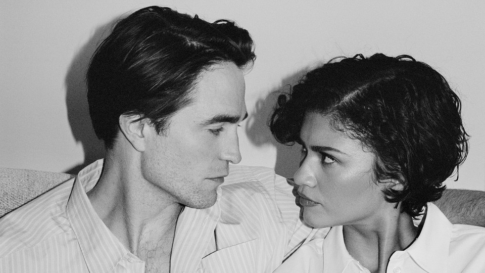 A black-and-white photo of Robert Pattison and Zendaya embracing and looking at each other.