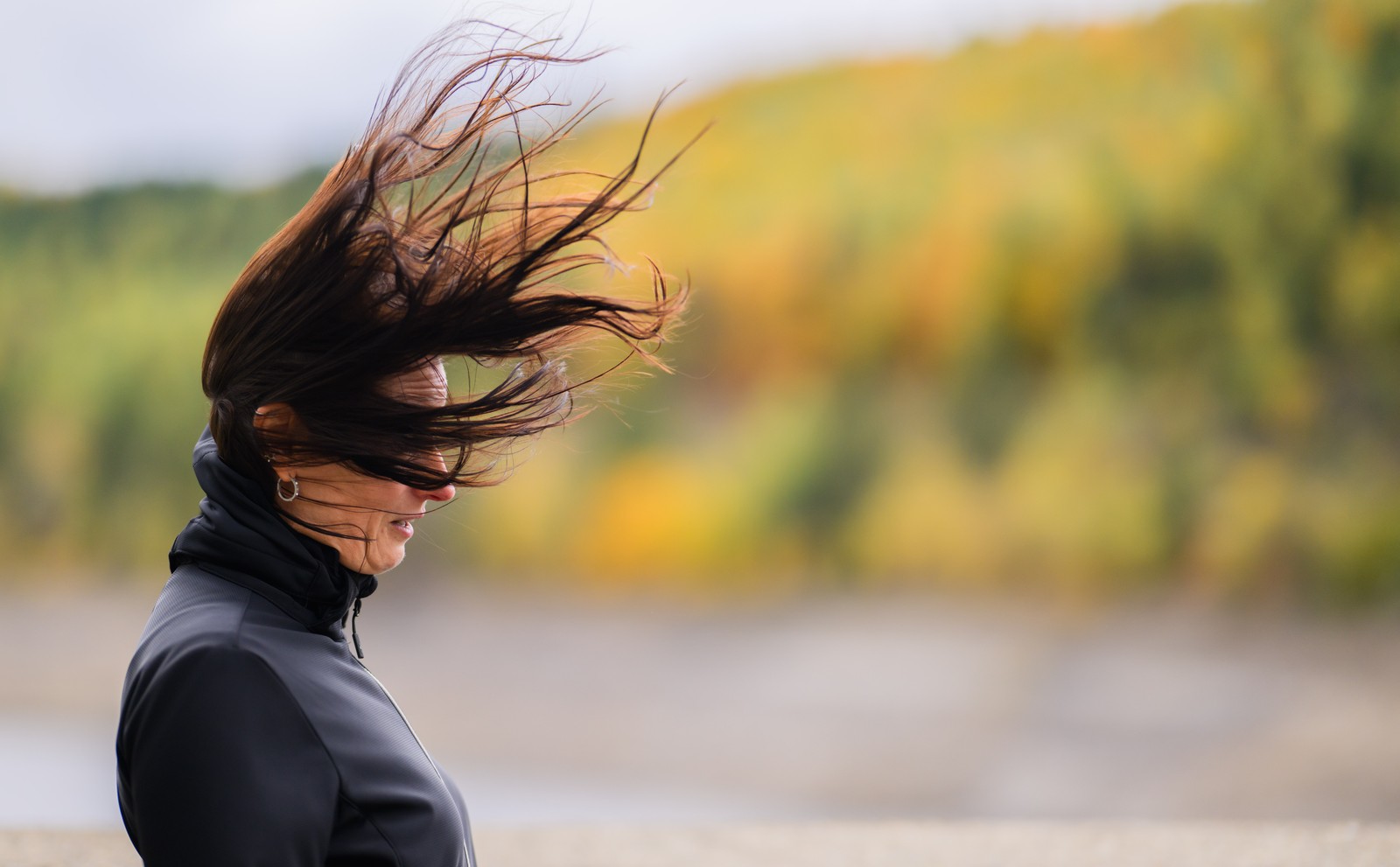 A person's hair is blown around by a strong gust of wind.