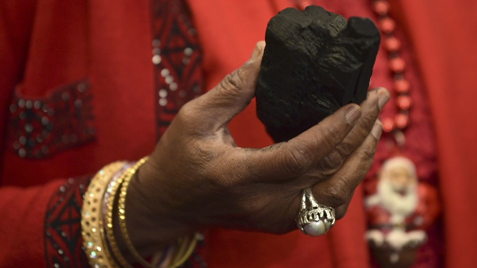 A woman holds a lump of coal