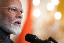 A photo shows Prime Minister Narendra Modi speaking into a microphone.