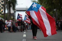 A Puerto Rican flag is waved during a protest against government austerity measures as the island faced a looming deadline to restructure its $70 billion debt in San Juan, Puerto Rico on May 1, 2017. 