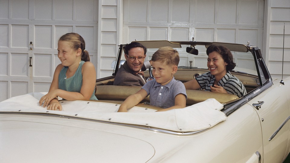 A family sits in a white convertible