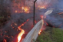 The lava flow from the Kilauea volcano moves over a fence on private property near the village of Pahoa, Hawaii, in 2014. 