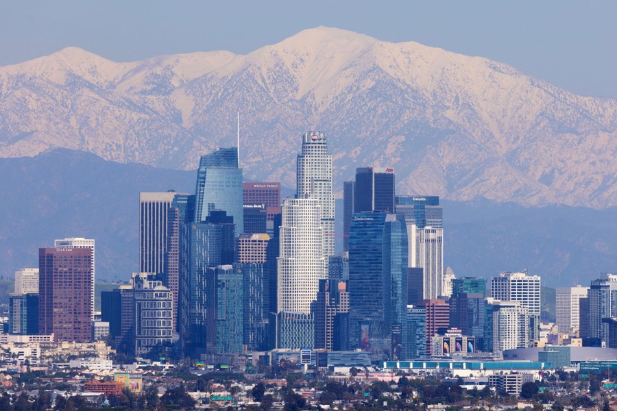 Snow-covered mountains, behind a city skyline