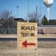 Signs point the way to measles testing in the parking lot of the Seminole Hospital District, across from Wigwam Stadium, on February 27, 2025, in Seminole, Texas.