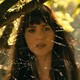 Dakota Johnson in “Madame Web,” standing in front of a spider web while backlit by the sun