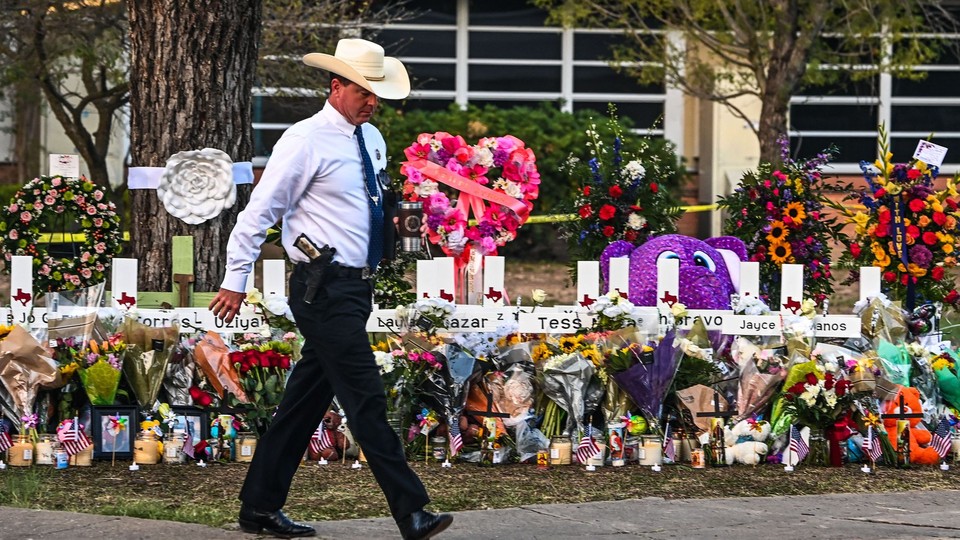 Police officer walking in front of a memorial