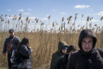 adults in a field wearing winter coats