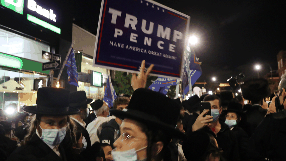 A protester holds up a Trump-Pence sign.