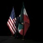 A staff member removes the Iranian flag from the stage next to the American flag.