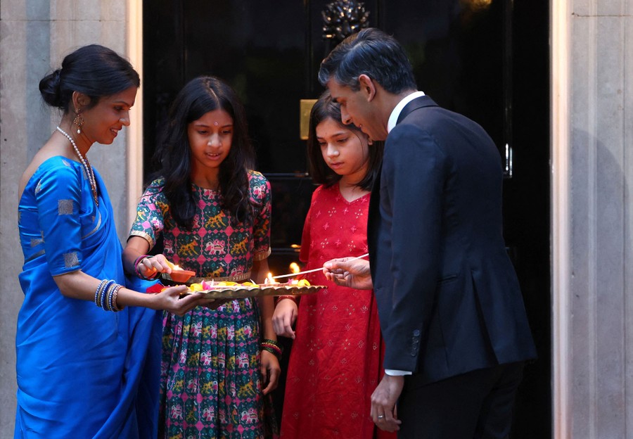 British Prime Minister Rishi Sunak and his family light candles together.