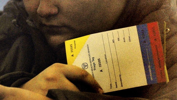 A person holding a card with triage colors