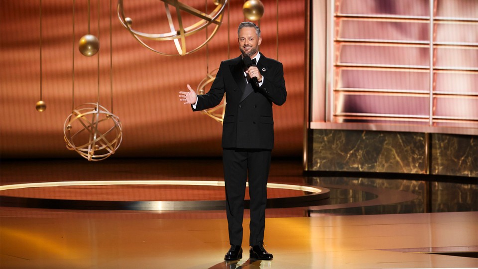 Nate Bargatze stands on the Emmys stage with a microphone