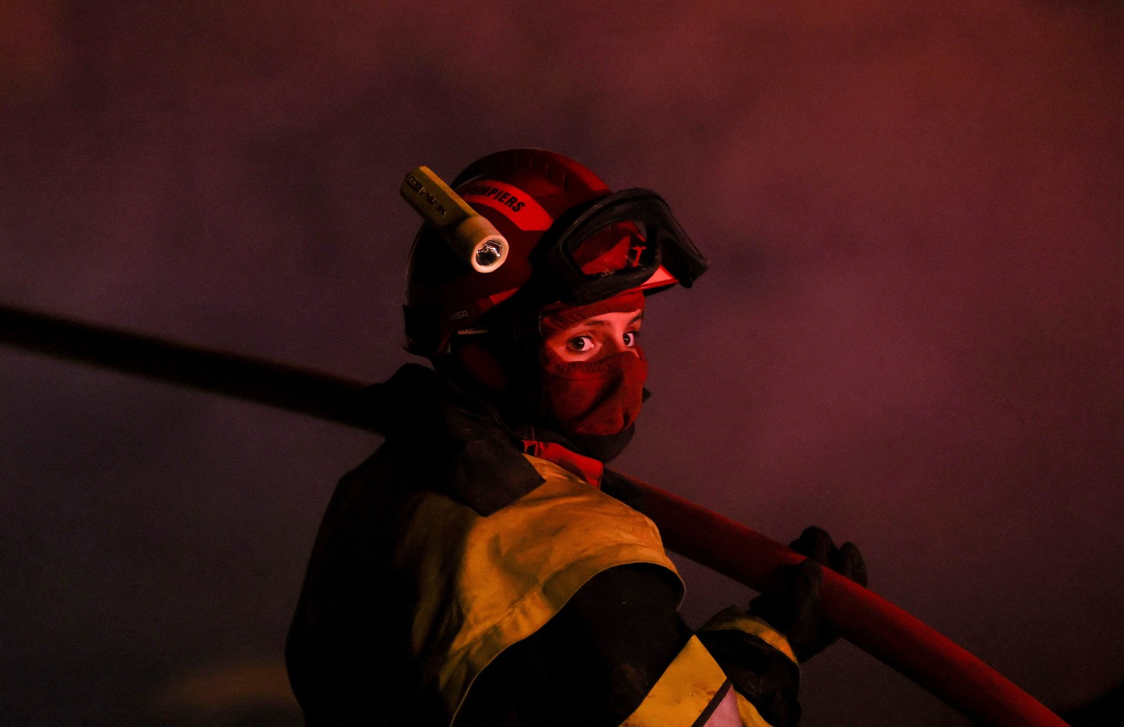 A close view of a firefighter working to extinguish a wildfire.