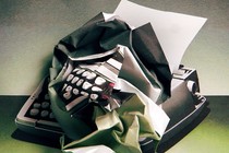 An illustration of a typewriter, the surface of which is transforming into a crumpled piece of paper