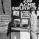 A man stands in front of employment signs