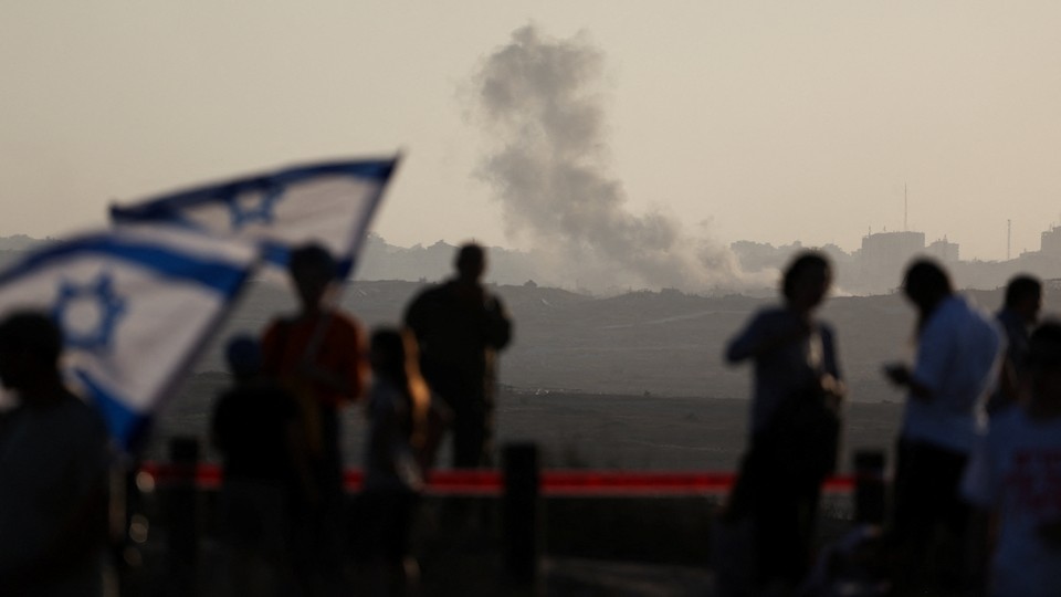Smoke rises from Gaza as Israeli right-wing activists take part in a rally organized by settlers groups to promote Israel's resettling in Gaza, as seen from the Israeli side of the Israel-Gaza border.