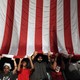 Sikh mourners holding up a large American flag