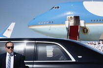 Photo of Donald Trump in a black car with Air Force One in the background